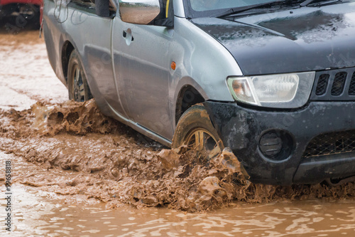 mud splash by a car as it goes through flood water