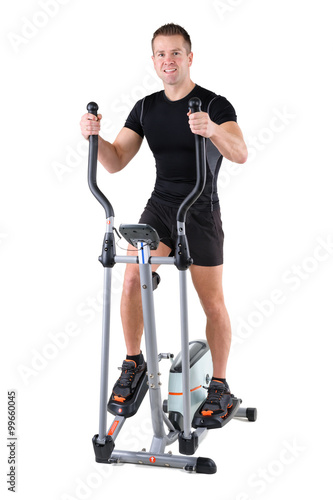 young man doing exercises on elliptical trainer