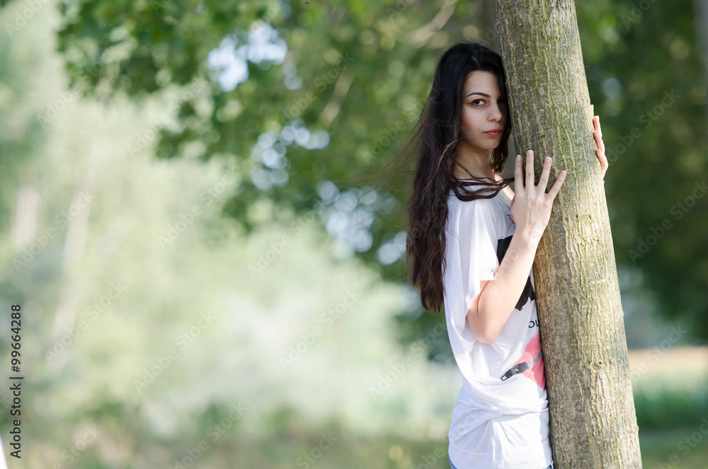 Amazing brunette lady with long curly hair, woman lying on tree Amazing brunette lady with long curly hair, woman lying on tree