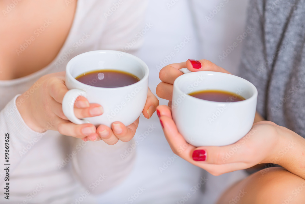 Two young ladies holding teacups. Two young ladies holding teacups.
