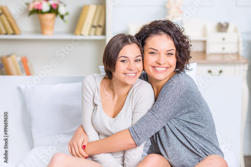 Foto One sister hugging another