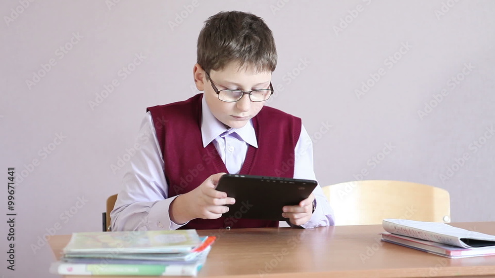 boy with glasses playing the tablet at school boy with glasses playing the tablet at school