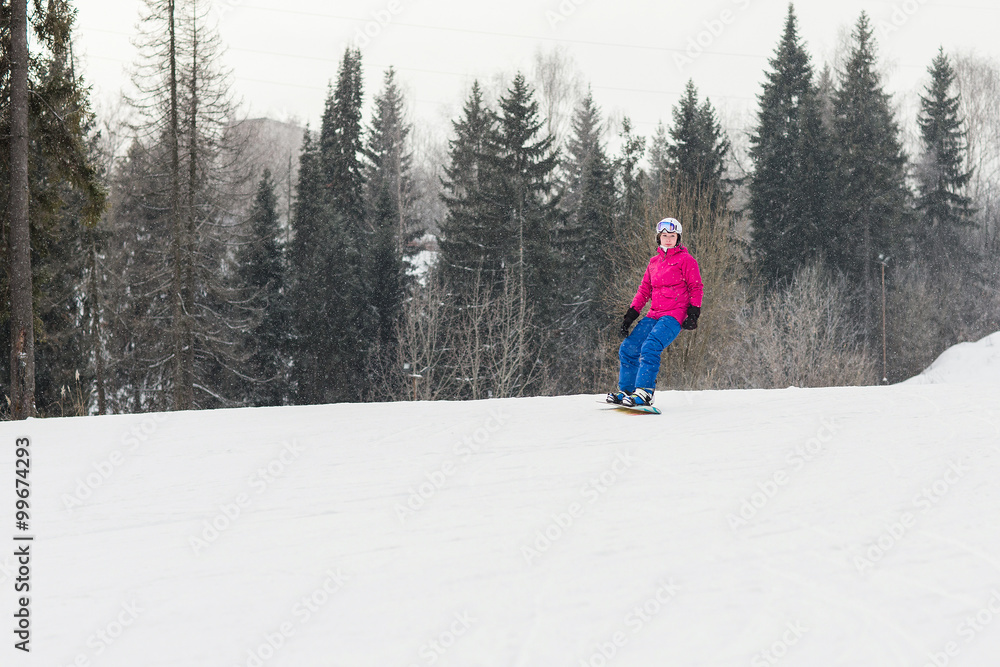 Woman snowboarder on the slopes frosty winter day. Beautiful girl on snoborde in the snow.