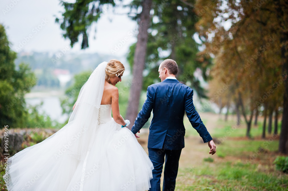 Married walking in the rain at park Married walking in the rain at park