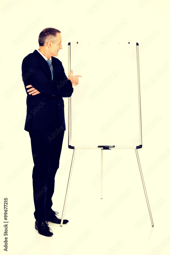 Male executive pointing on flip chart