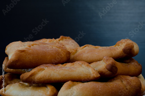 Plate with fresh fragrant pies on a black wooden table, lunch, echpochmak photo