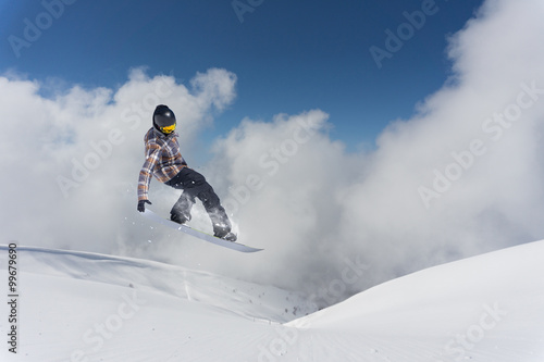 Flying snowboarder on mountains. Extreme sport.