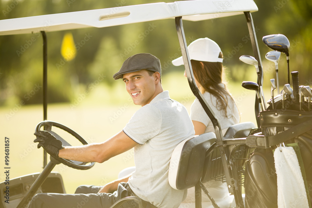 Young couple at golf cart Young couple at golf cart