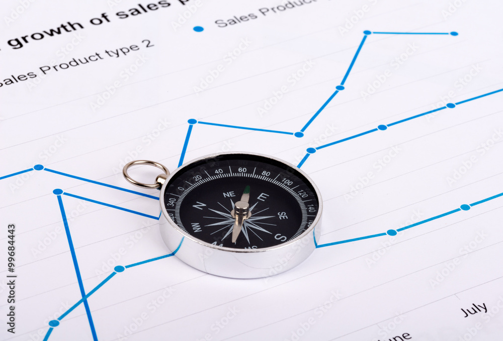 Business concept with compass and graph on paper Business concept with compass and graph on paper