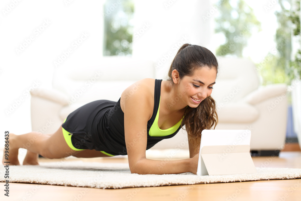Fitness woman exercising watching fitness videos Fitness woman exercising watching fitness videos
