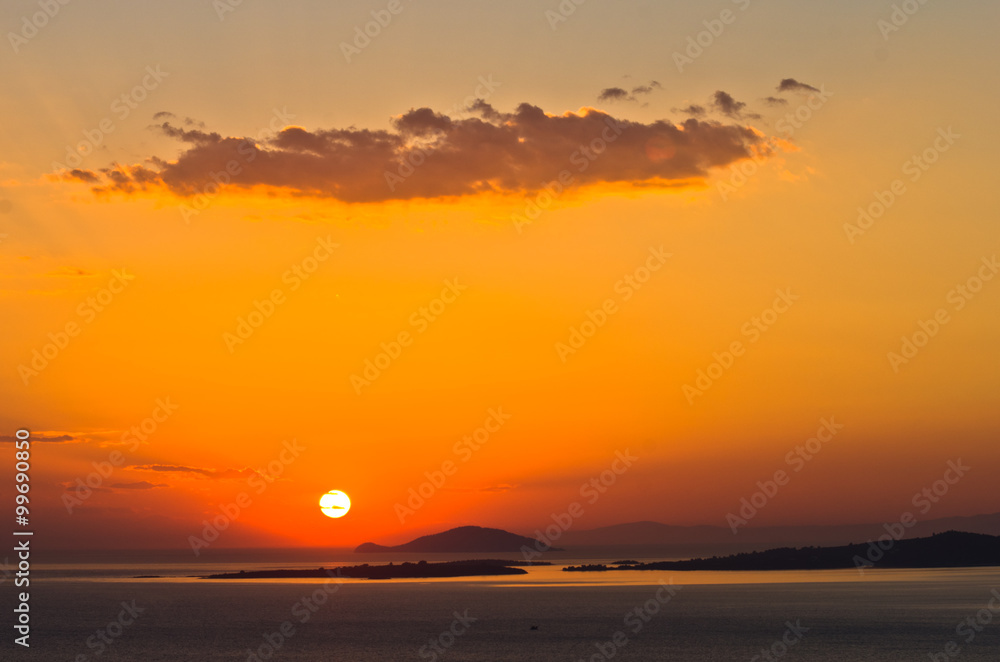 Sunset at sea, with small greek islands in background