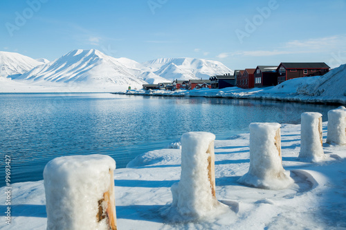 LONGYEARBYEN, SPITSBERGEN, NORWAY - APRIL 08, 2015: Small town on the shores of the Arctic ocean among snow-capped mountains of the Norwegian archipelago of Svalbard.