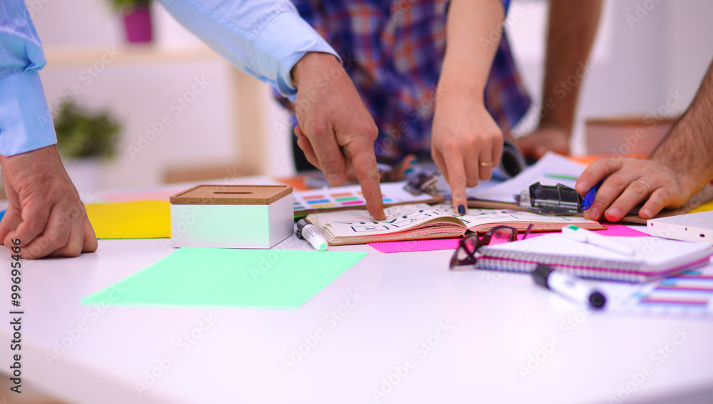 Obraz premium Close-up of three young creative designers working on project together. Team work