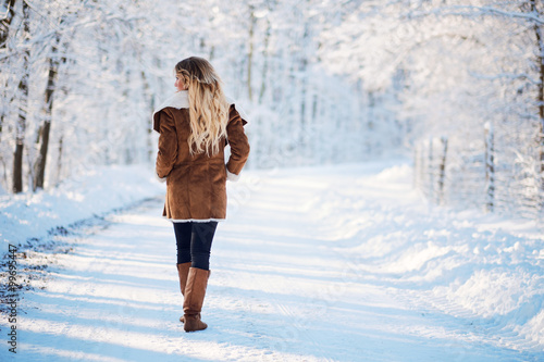 Young blonde woman walking winter park photo