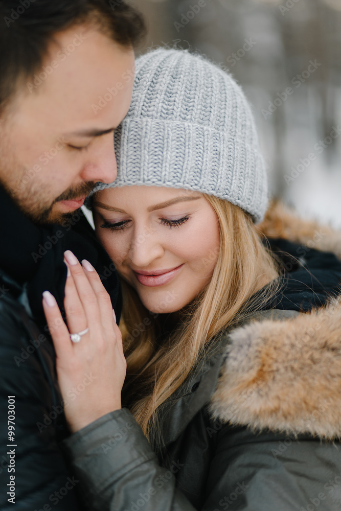 Cute young hipster couple having fun in winter park on a bright day hugging each other and smiling
Cute young hipster couple having fun in winter park on a bright day hugging each other and smiling