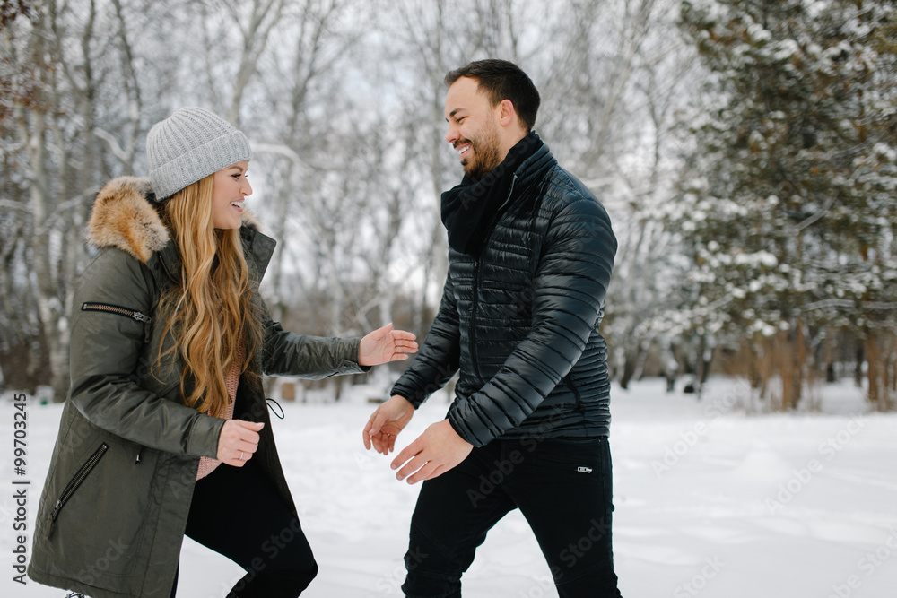 Cute young hipster couple having fun in winter park on a bright day hugging each other and smiling
Cute young hipster couple having fun in winter park on a bright day hugging each other and smiling