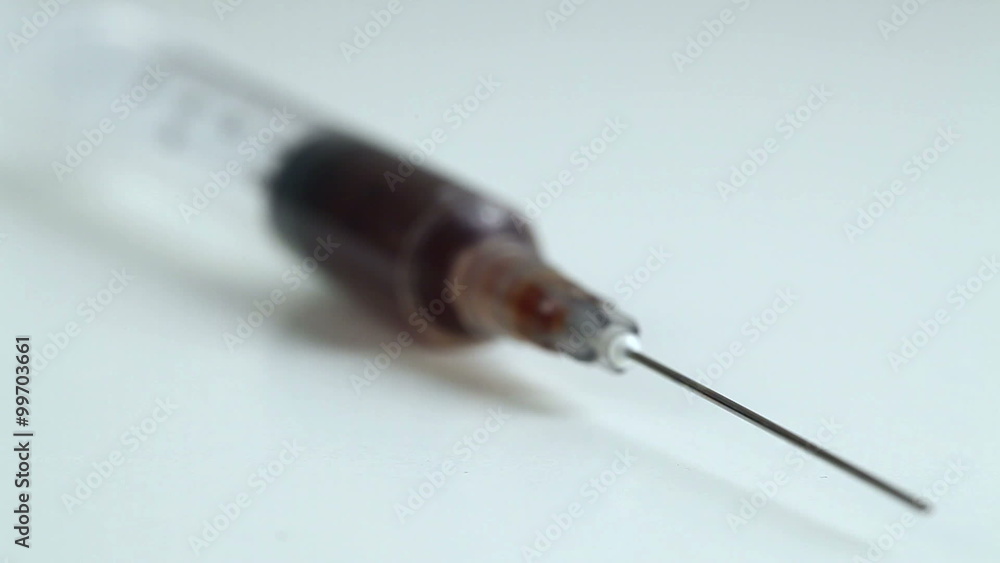 A syringe lying on a white table A syringe lying on a white table