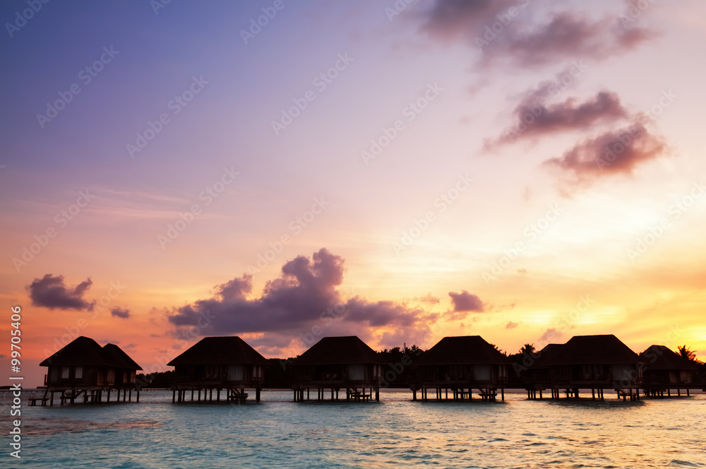Sunrise over water bungalows in Maldives Sunrise over water bungalows in Maldives