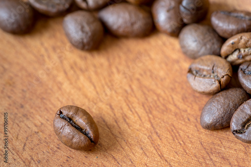 Detail view of coffee beans on wooden background. Macro shoot.