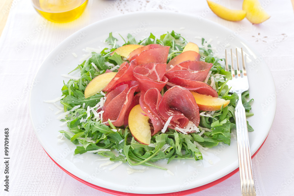 Delicious italian fresh salad with bresaola arugula and cheese on white plate Delicious italian fresh salad with bresaola arugula and cheese on white plate