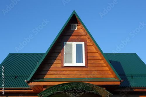 Green metal roof  and attic window closeup