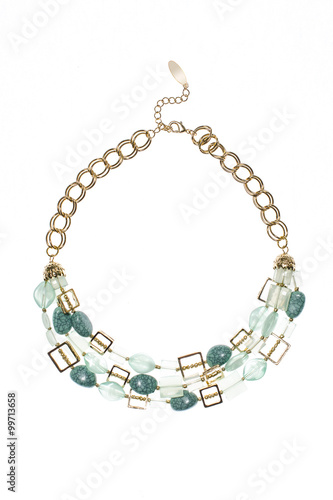 gold necklace with green gems on a white background