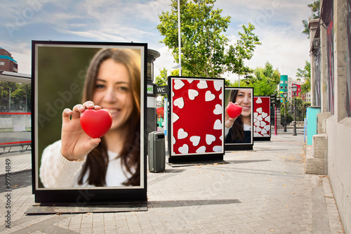 Love billboards, photographs of a woman with red heart, at city