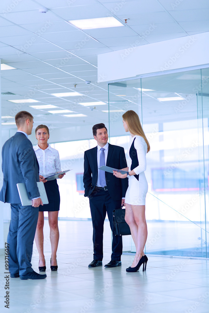Smiling successful business team standing in office Smiling successful business team standing in office