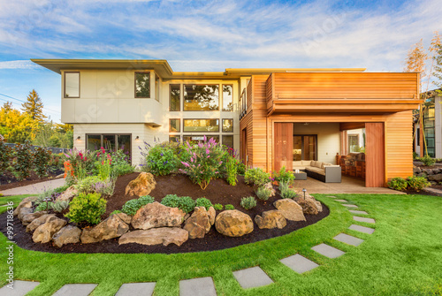 Beautiful Luxury Home Exterior  with Balcony and Green Grass on Sunny Afternoon photo