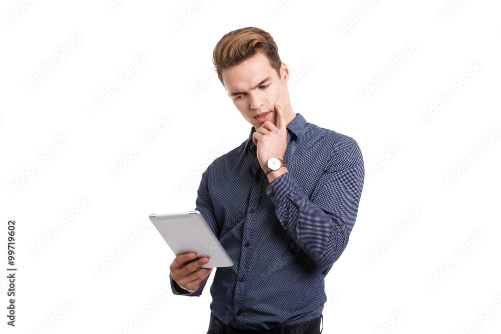 Young man Looking at a tablet, isolated in white Young man Looking at a tablet, isolated in white
