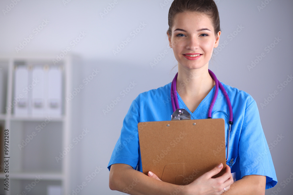 Smiling female doctor with a folder in uniform standing at hospital Smiling female doctor with a folder in uniform standing at hospital