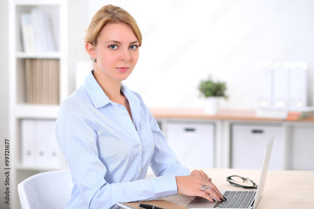Young blonde business woman with laptop in the office. Business concept. Young blonde business woman with laptop in the office. Business concept.