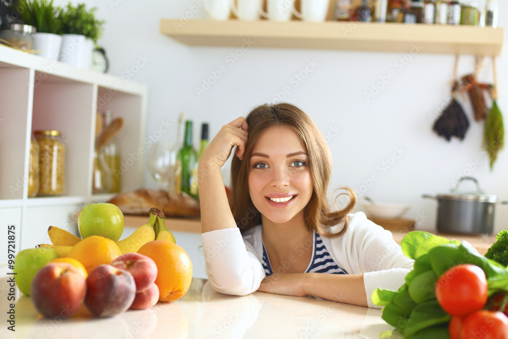 Young woman sitting near desk in the kitchen