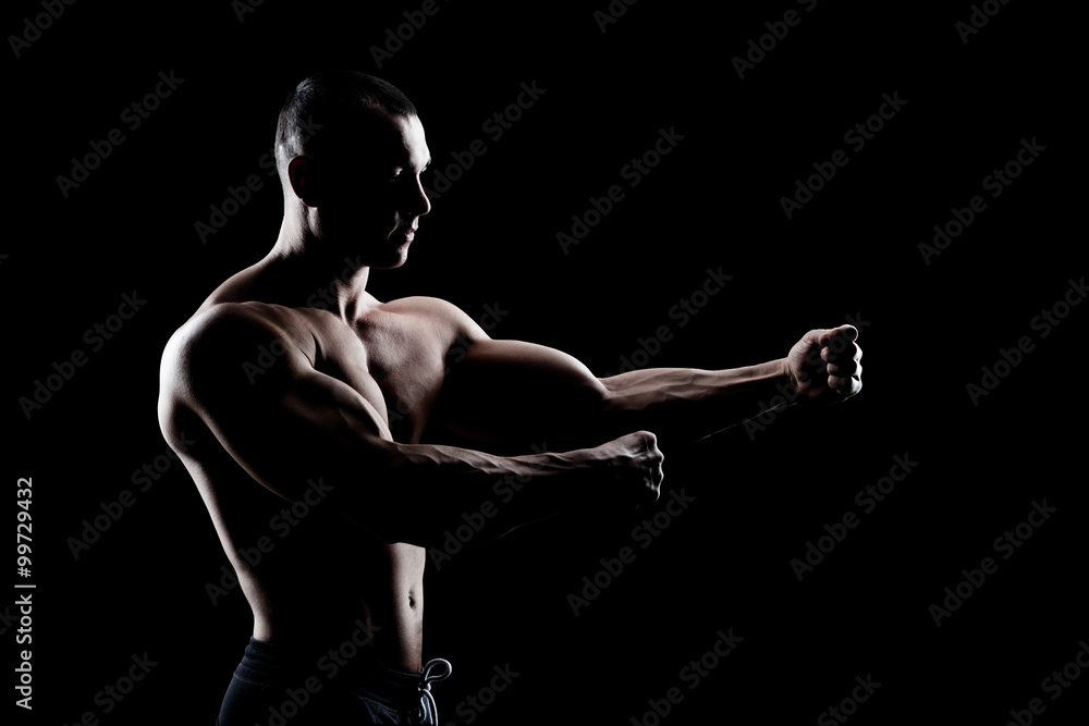 Fototapeta premium bodybuilder demonstrates biceps on a dark background