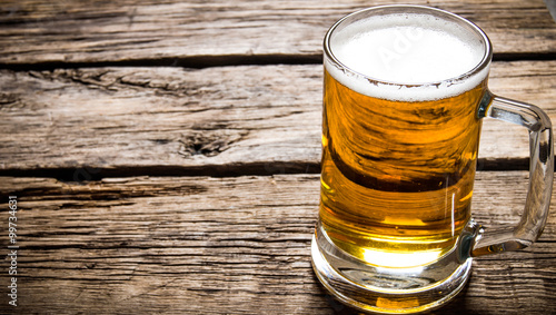 Εκτύπωση καμβά Glass of light beer on wooden table.