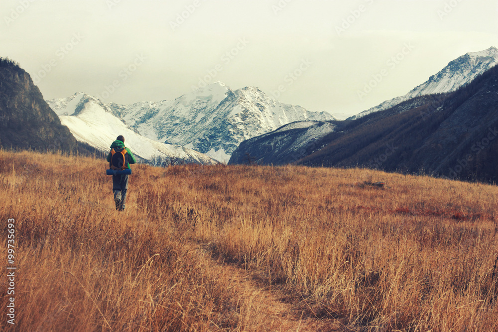 Backpacker go into the mountains. Happy travel concept. Mountain trekking. Man in harmony with nature. Autumn mountain landscape. 
