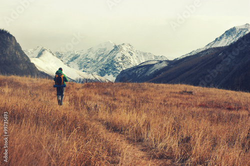 Backpacker go into the mountains. Happy travel concept. Mountain trekking. Man in harmony with nature. Autumn mountain landscape. 
 photo