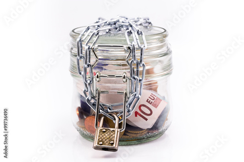 glass jar with money and locked chain