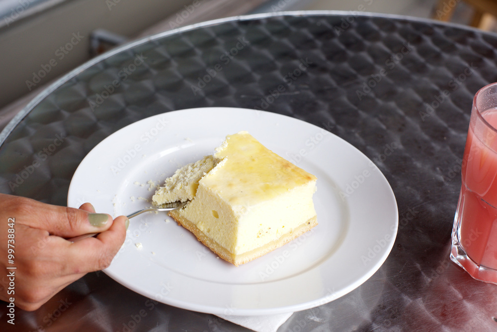 Female hand taking a slice of cake with fork Female hand taking a slice of cake with fork