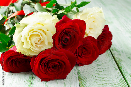 Red and white roses on wooden background