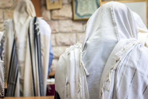 Jewish men praying in a synagogue with Tallit 