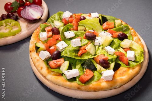 Wonderful pizza with cheese and a lot of vegetables served on wo
