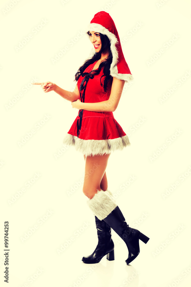 Woman wearing santa clothes pointing Woman wearing santa clothes pointing