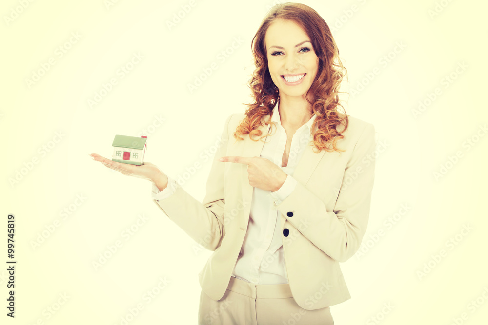 Businesswoman pointing on a model house. Businesswoman pointing on a model house.