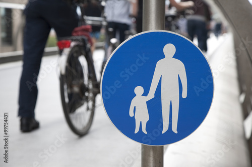 Pedestrian Sign with bicycle and people in the background