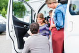 Familie kauft Auto beim Autohändler, ein Van wird das neue Familienauto