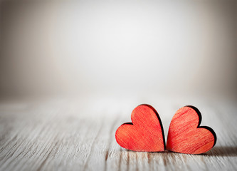 Valentines day background with two red hearts on wooden background