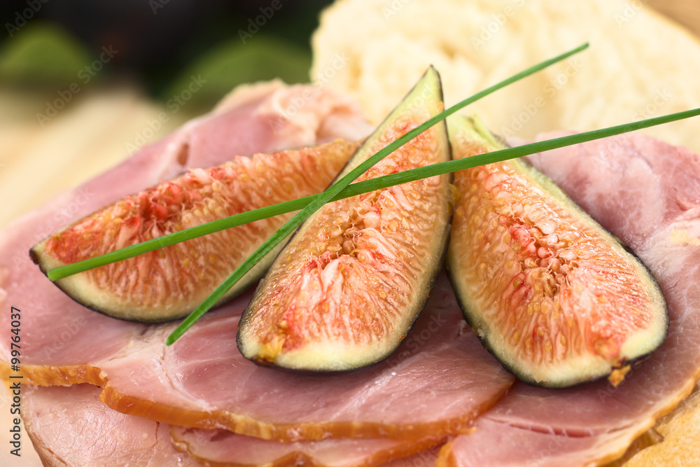 Fresh fig slices on smoked ham sandwich garnished with chives (Selective Focus, Focus on the middle of the image) Fresh fig slices on smoked ham sandwich garnished with chives (Selective Focus, Focus on the middle of the image)