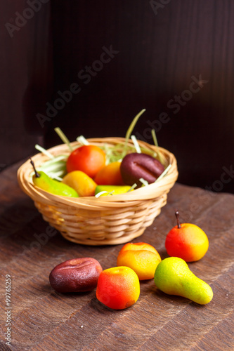 A basket of chocolates from marzipan in the form of fruits is no