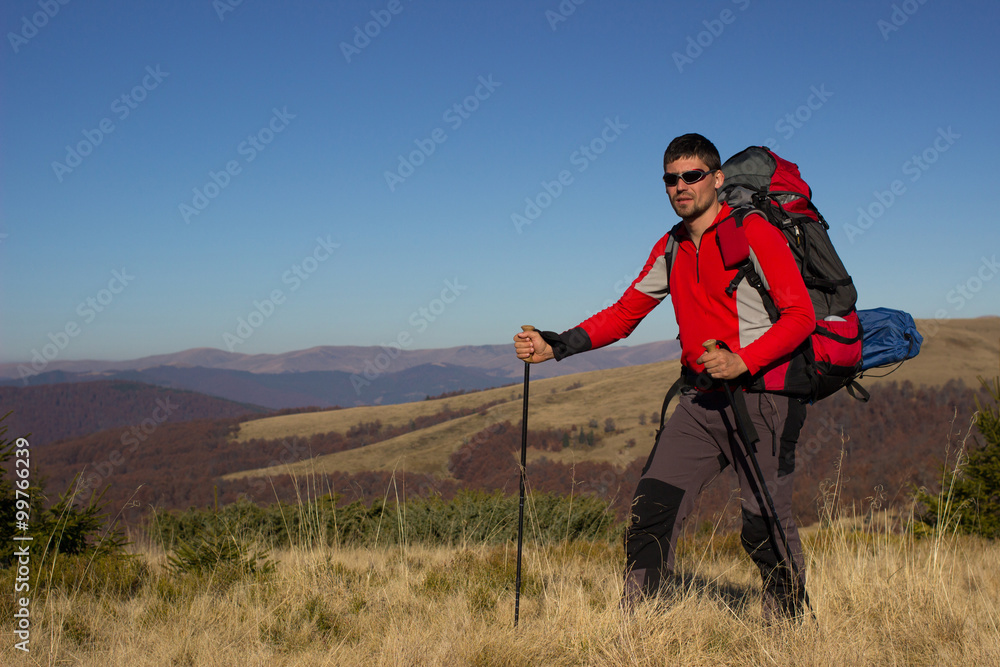 Hiker hiking in the mountains on a sunny day. Hiker hiking in the mountains on a sunny day.